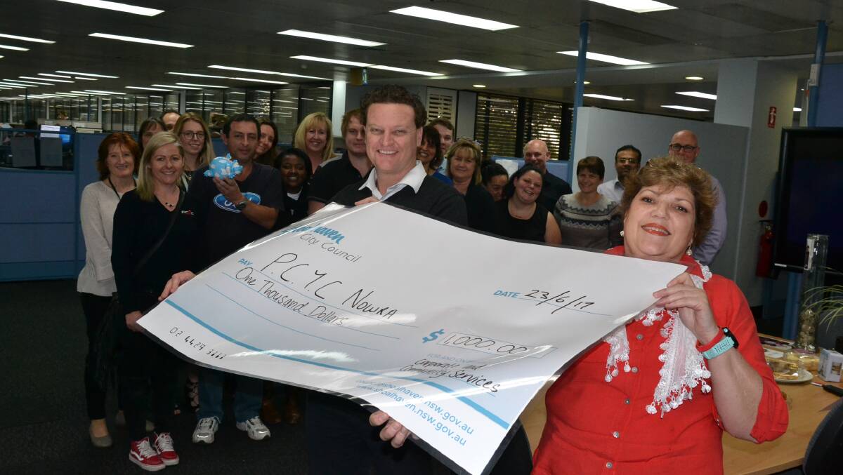 SUPPORT: Shoalhaven City Council’s Corporate and Community Service Group staff member Trish Bird presents a $1000 donation from its mufti day fundraisers to PCYC Shoalhaven manager Jeff Morris.