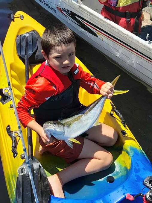 Logan Walker, 8, of Griegs Flat shows his lovely kingfish taken with whitebait while kayak fishing in Merimbula Lake.