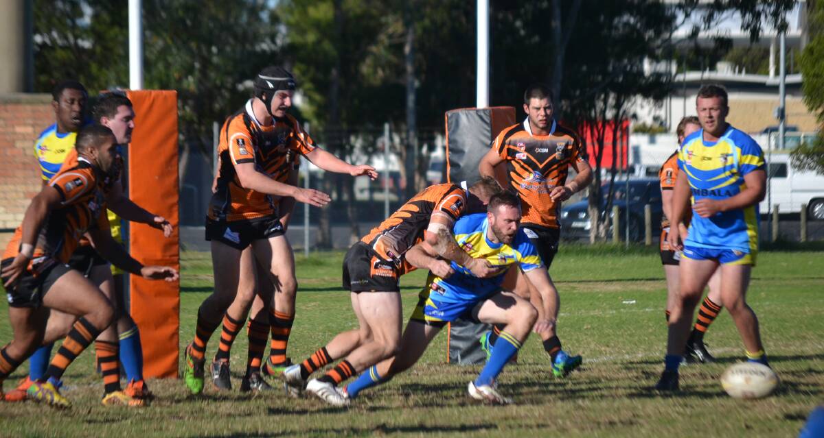 FIRST GRADE: Bombala Blue Heeler Andrew Guthrie is tackled by the Bay Tigers watched by Bombala's Paul Gimbert and Saimoni Buinimasi during Sunday's game at the Bay.