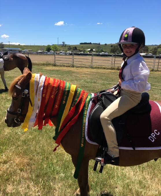 RIDING HIGH: Delegate Pony Club rider Gabby Kidd with her swag of ribbons won in the Under 9s at Delegate Pony Club's highly successful gymkhana on Sunday.