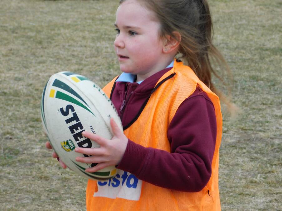 Bombala Public School K-6 student Jenaya Tonks gets ready to pass the football during rugby league training at school.