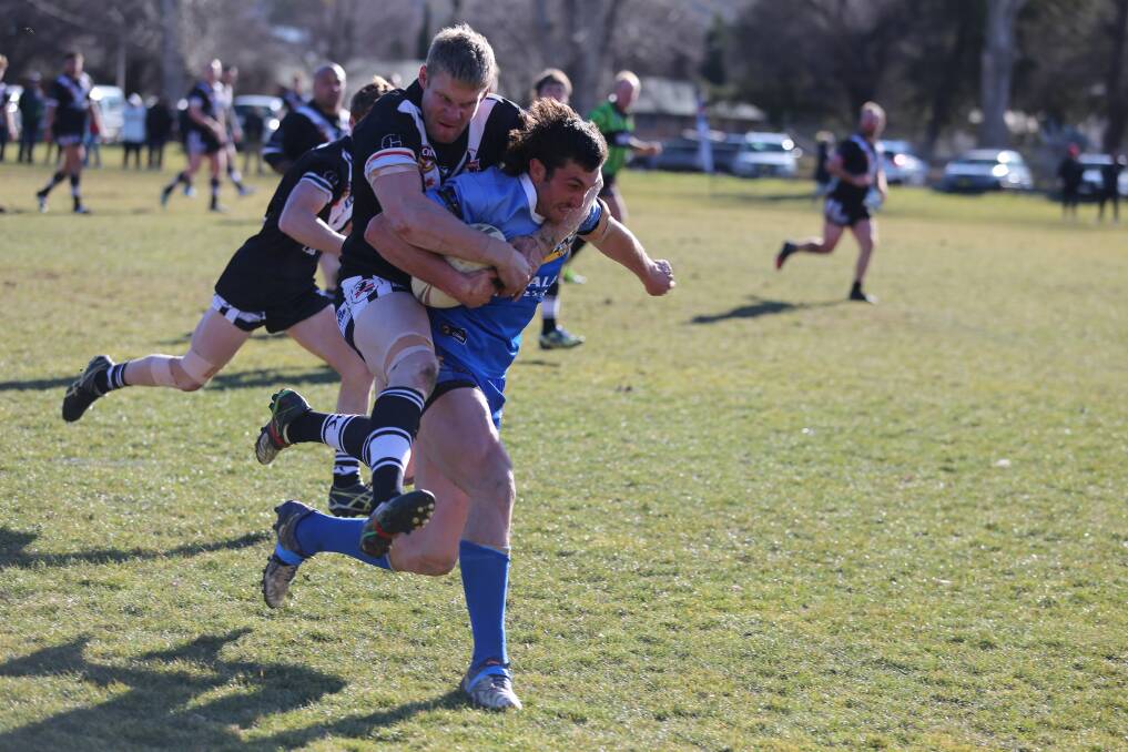A Cooma Stallion tries to tackle Bombala Blue Heeler captain coach Joe Bobbin as he races for the line during Sunday's semi-final at Cooma.
