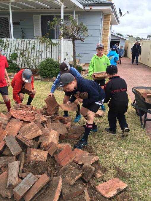 GOOD WORK: The Cooma North Public School rugby league boys help to move a load of wood for an elderly gentleman in Goulburn after their football game on Saturday.