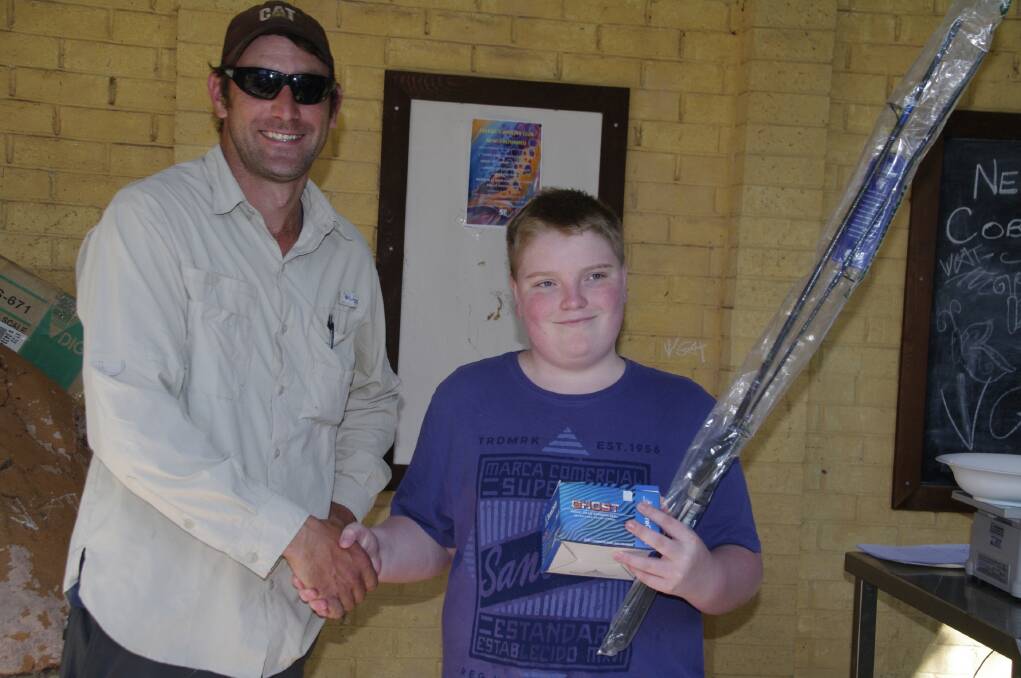 Delegate Fishing and Angling Club representative Stephen Woelfle presents Caleb Tonks with his prize for the best fish at the Delegate Duck and Boat races on Good Friday.