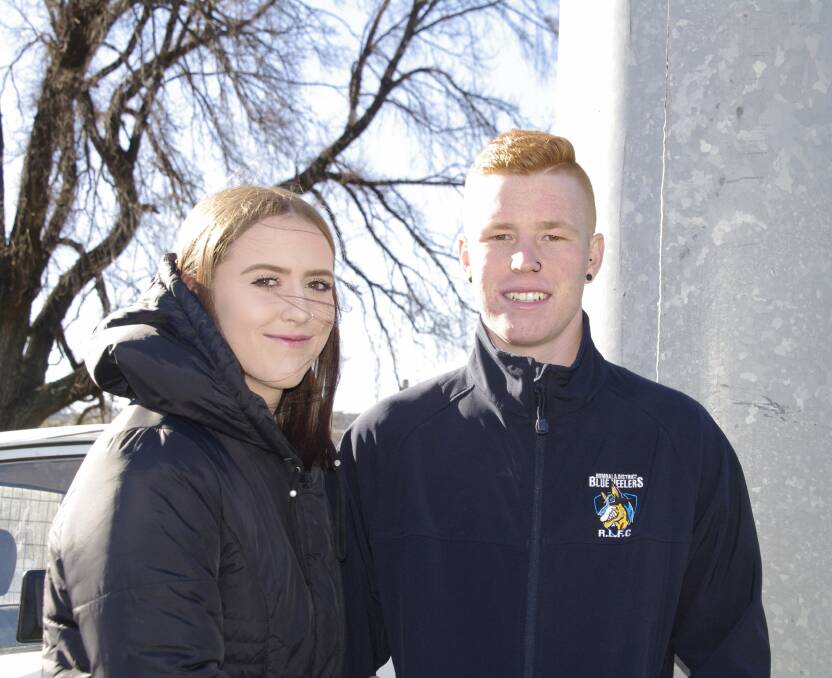 Tyler Jones keeps warm before his first grade game with the Blue Heelers against the Moruya Sharks at Bombala on Sunday. With him is Keyara Marshall.