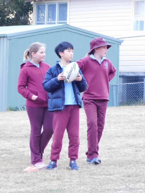 Bombala Public School K-6 students Harry Lee, Montana Schofield and Bridie Hampshire pick up a few tips during Rugby League training.
