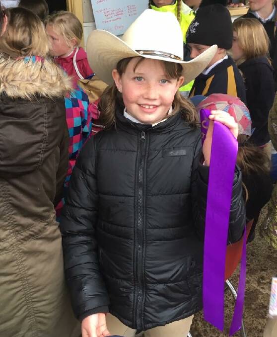 Delegate Pony Club member Emily Vincent was happy to collect her ribbon at the Cooma Pony Club rally day on Sunday.