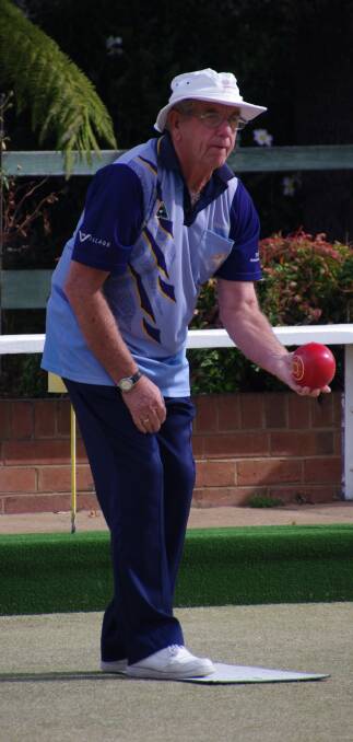 Brian Douch concentrates on the line he would like his bowl to take during a weekend game of lawn bowls at the Bombala RSL Bowling Club.