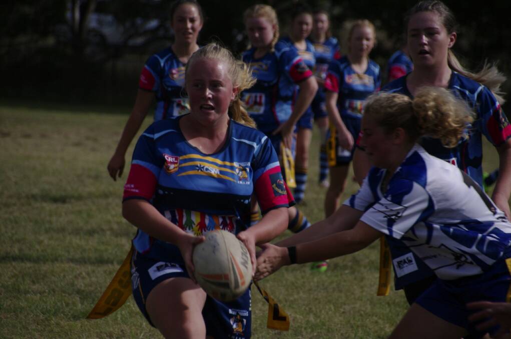 Pink Heeler Brieanna Hepburn carves a path through the opposition and the Junior Rugby League footy match recently.