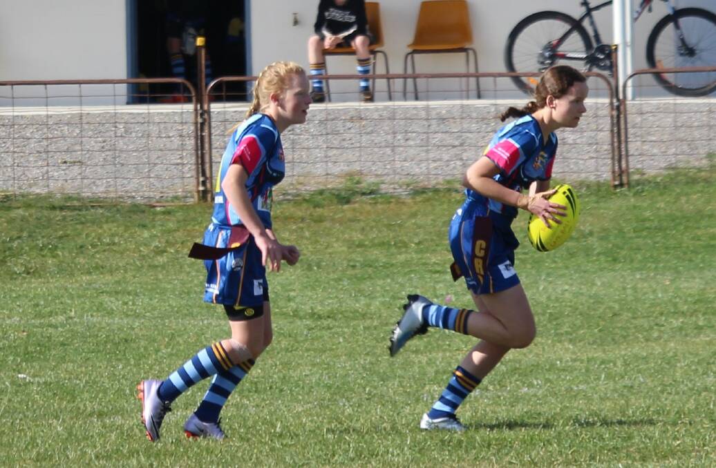 Pink Heelers Emily Perkins and Bree Brownlie run with the ball during the Girl's League Tag game against Moruya.
