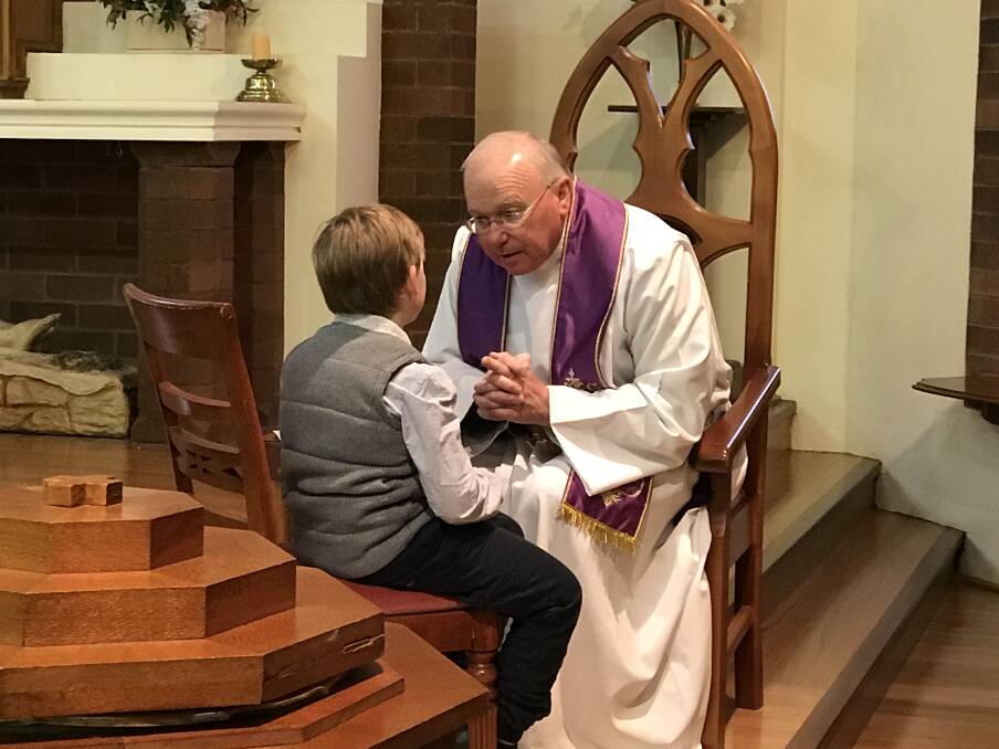Henry Power making his confession with St. Mary's Catholic Church priest Father Mick MacAndrew on Saturday.