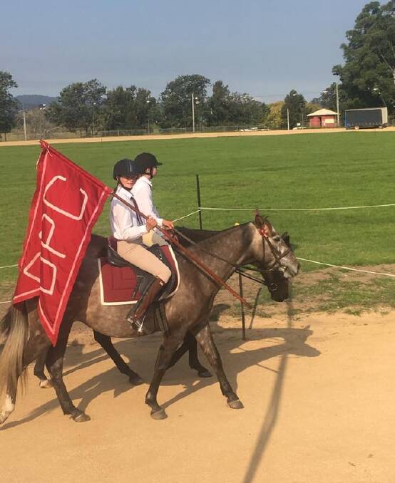 BEGA PONY CLUB: Rochelle Voveris holding flag, parading with Jessica Vincent riding in a parade with their Delegate Pony Club flag raised proudly.  