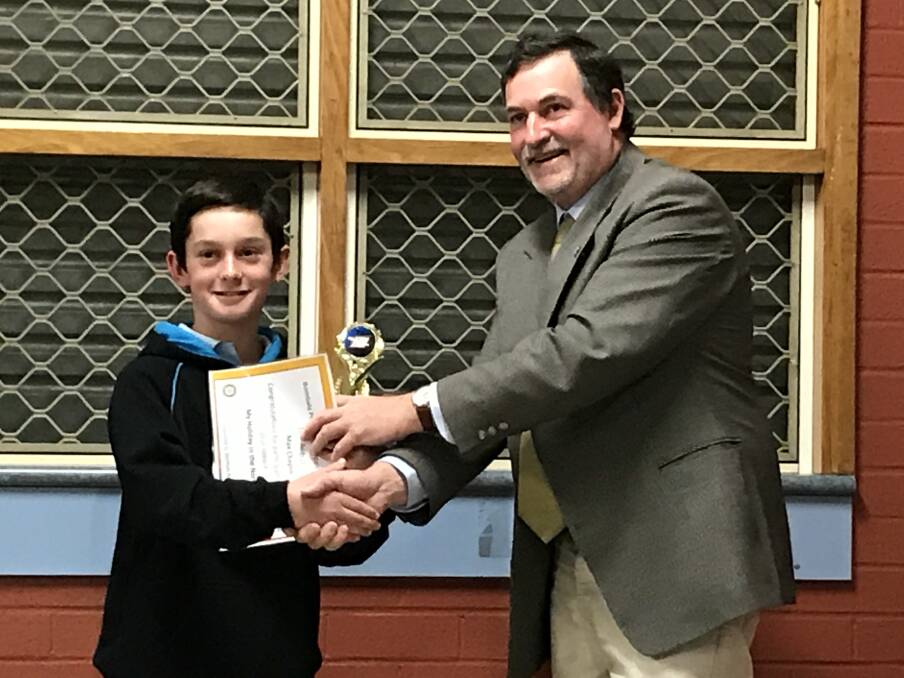 BEST SPEAKER: Rotarian Grantley Ingram presents Max Chaplin from St. Joseph's Primary School with the trophy for the overall winner at the Public Speaking evening.