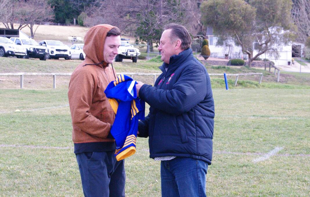 1991 Bombala Rugby League premiership player Peter Jones presents his son Bayley with his jersey at Saturday's Heritage game against Bega.
