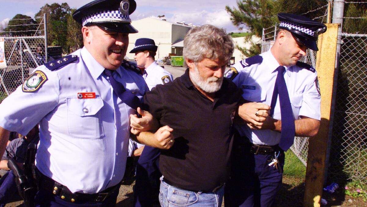 Police escort Wayne Phillips, then an organiser with the AMWU, from a picket line in 2000.