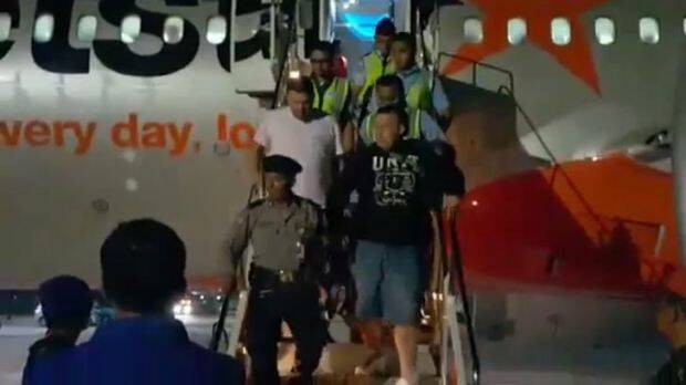 The men being escorted from the Jetstar plane in Bali. Photo: Supplied
