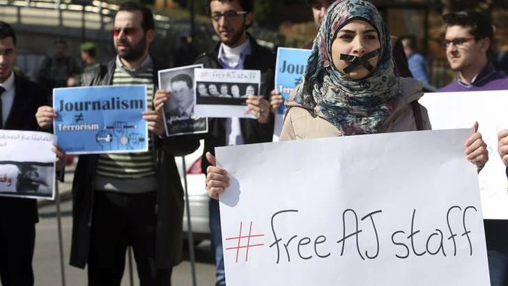 A protester, with a taped mouth, stands with a sign during a protest against the detainment of Al Jazeera journalists in Egypt, in Beirut February 8, 2014. Photo: Reuters