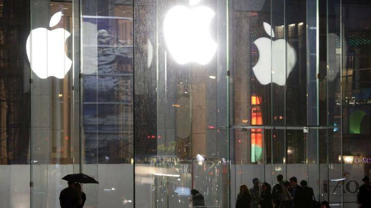 Pedestrians pass the Apple store location on Fifth Avenue, New York. Apple is one of many US multinationals that has been criticised for not paying enough tax in Australia. Photo: Frank Franklin