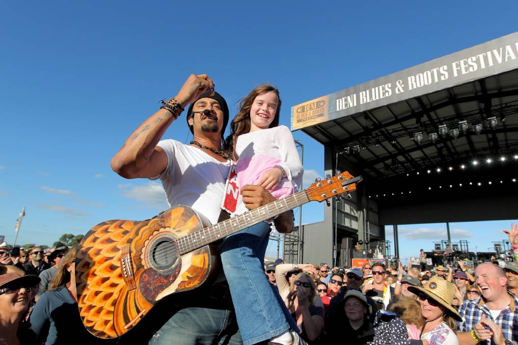 Michael Franti gives Jade Ramsay, 9, from Mornington Peninsula, a thrill as he performs in the crowd. Pictures: DAVID THORPE
