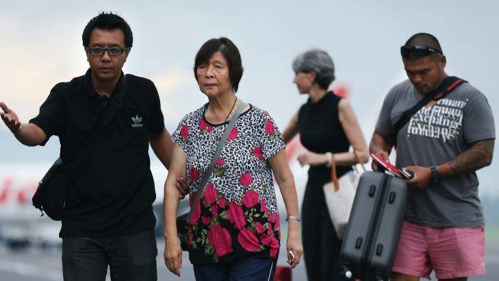 Australian consulate staff assist Helen Chan, the mother of Bali nine member Andrew Chan, followed by his brother Michael Chan as they arrive at Yogyarkarta airport. Photo: Kate Geraghty