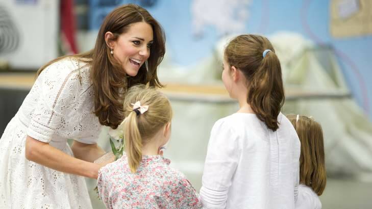 League fan ... the Duchess of Cambridge asks a couple of kiddies what the halftime score is in the Bulldogs-Souths match.