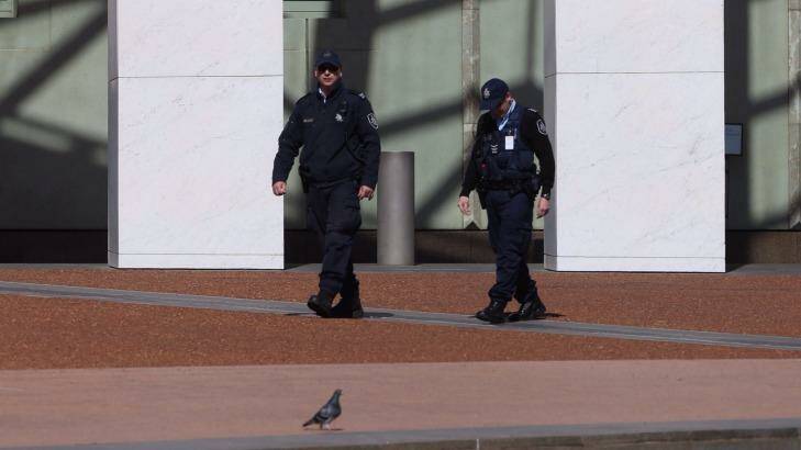 Australian Federal Police officers patrol Parliament House after terrorist threats escalated security concerns. Photo: Andrew Meares