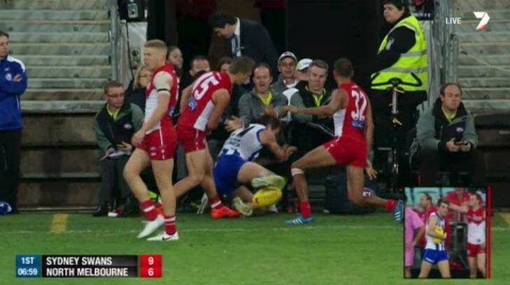 Down and out: Luke McDonald is slung into officials seated between the interchange benches by Kieren Jack.  Photo: Channel Seven