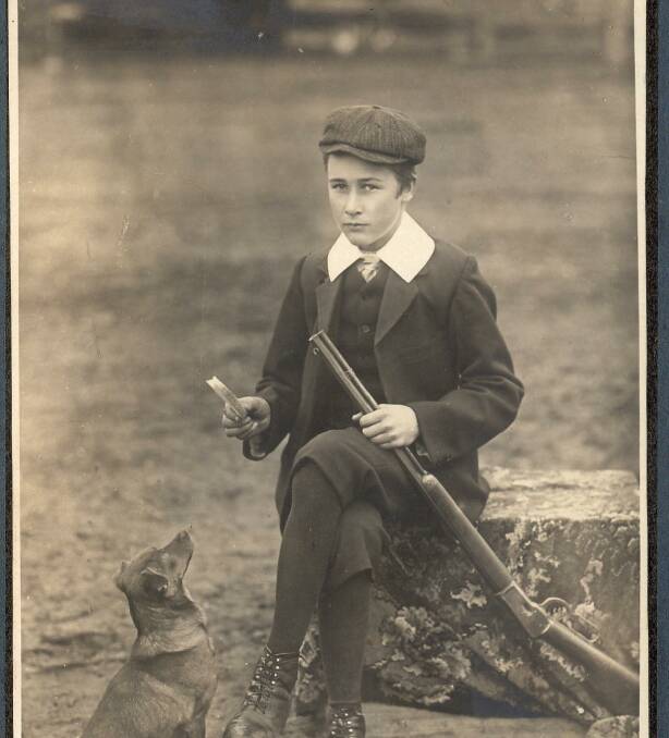 n A young Robert Paterson holds up a treat for his dog Nugget.
