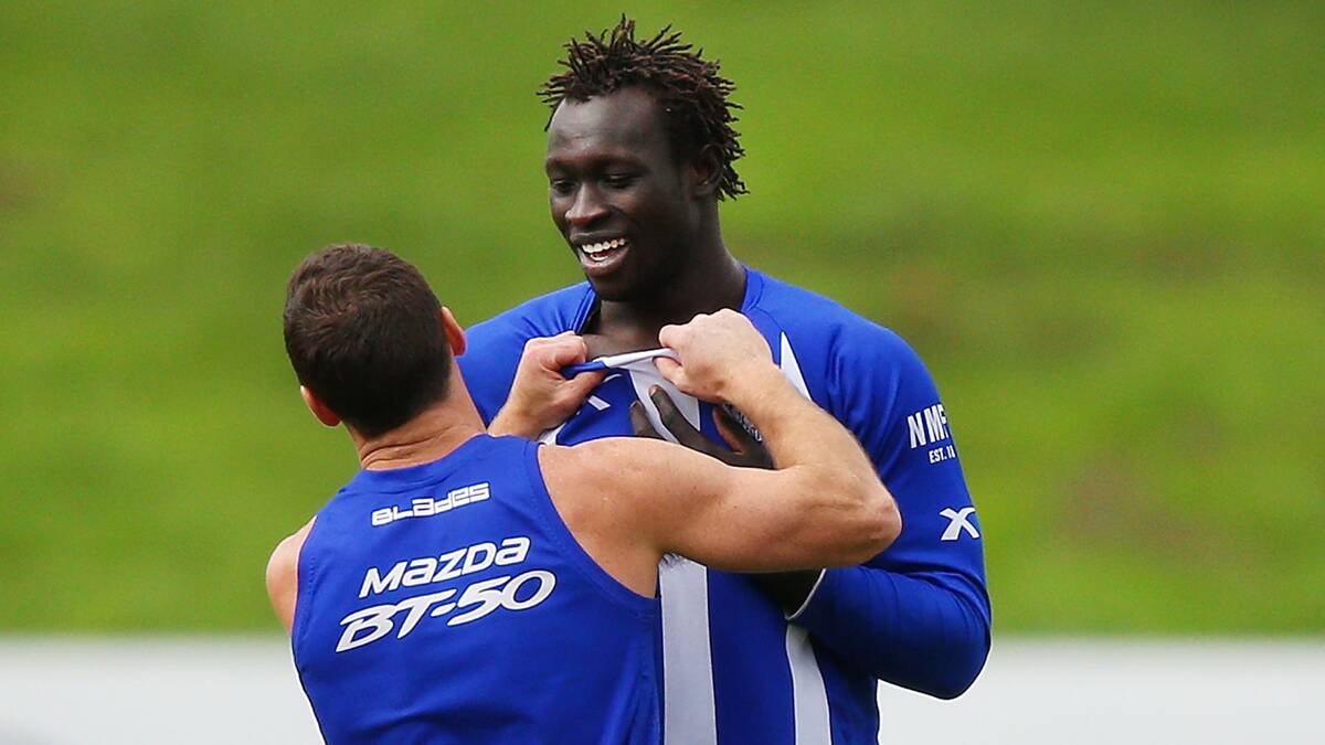 Brent Harvey (left) has a playful shove and shove with Majak Daw during a North Melbourne Kangaroos AFL training session on June 25. Picture: Getty Images. 
