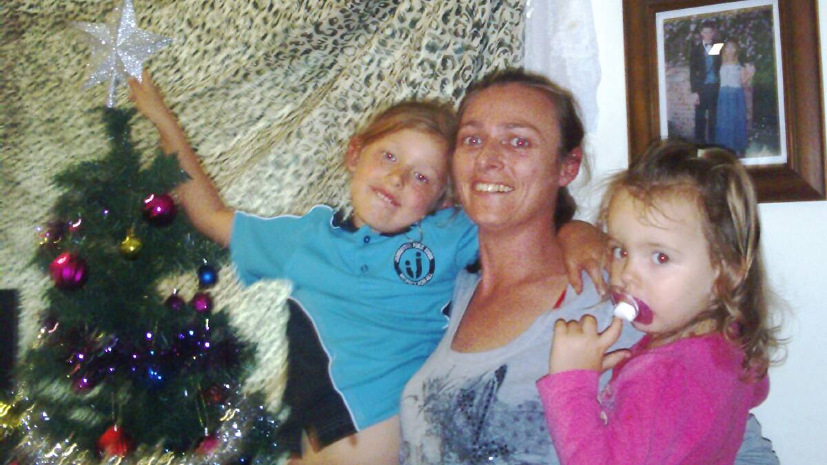 Belinda Hillier and her daughters Maddison and Charlie place a star on their Christmas tree in memory of their mother and grandmother Sylvia Pajuczok.