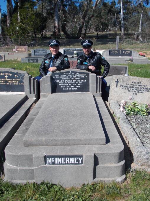 Constables Nathan Marks and Steven Gay kneel beside Constable McInerney’s grave in Bombala Cemetery.
