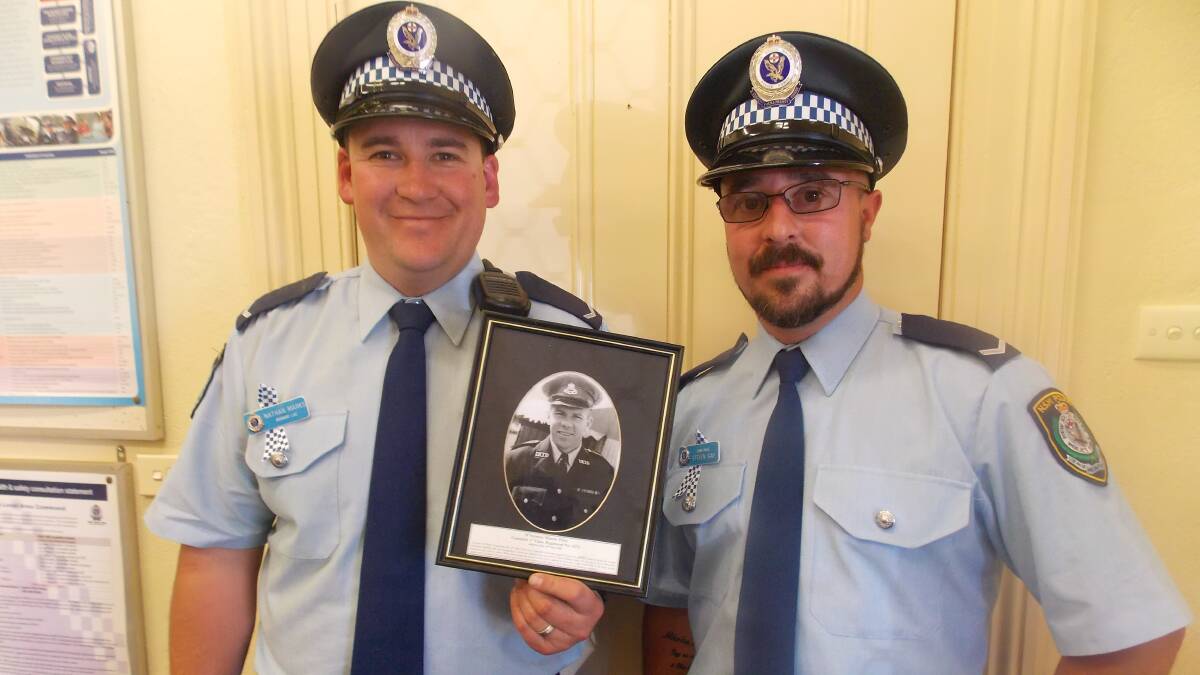 Constable Nathan Marks and Constable Steven Gay with a photo of Constable Stanley Peter McInerney who was killed while on duty in Bombala in 1958.