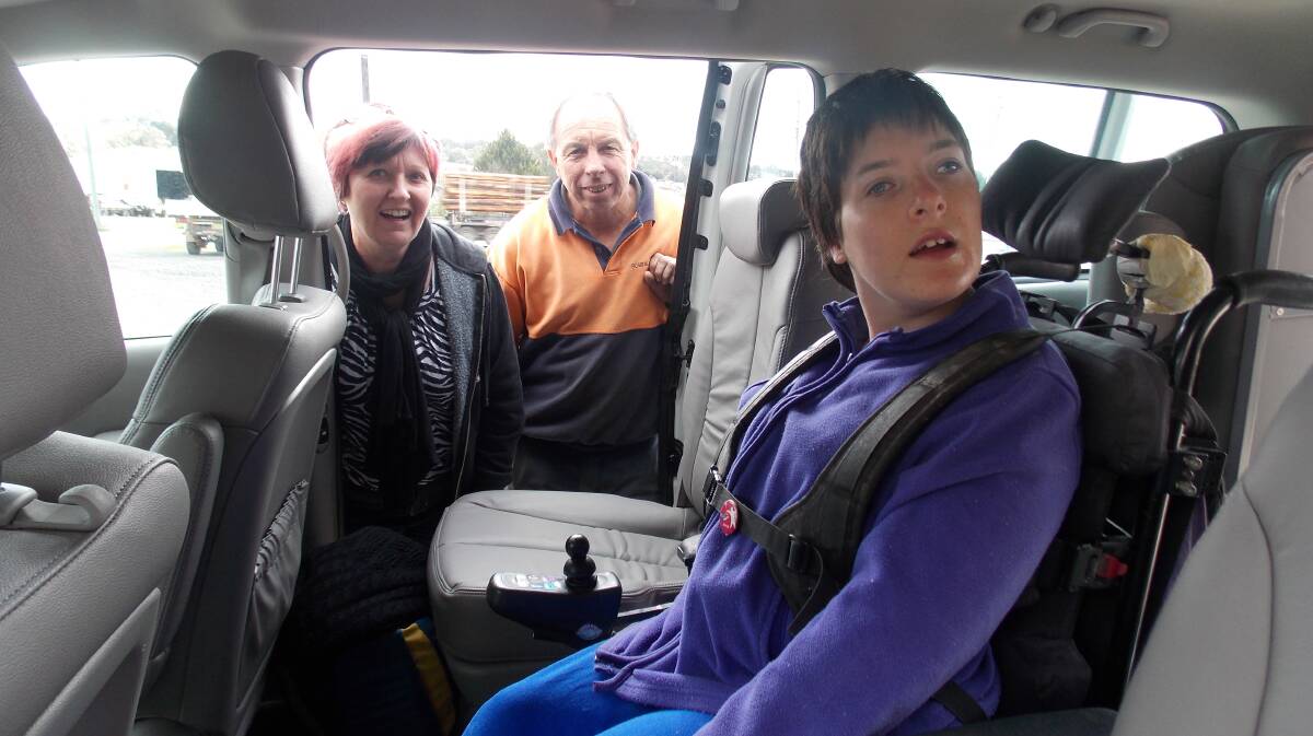 Colleen Barrett enjoys the comforts 
of the new vehicle that was funded 
by the kindness of strangers as her parents, Janelle and Richard, look on.