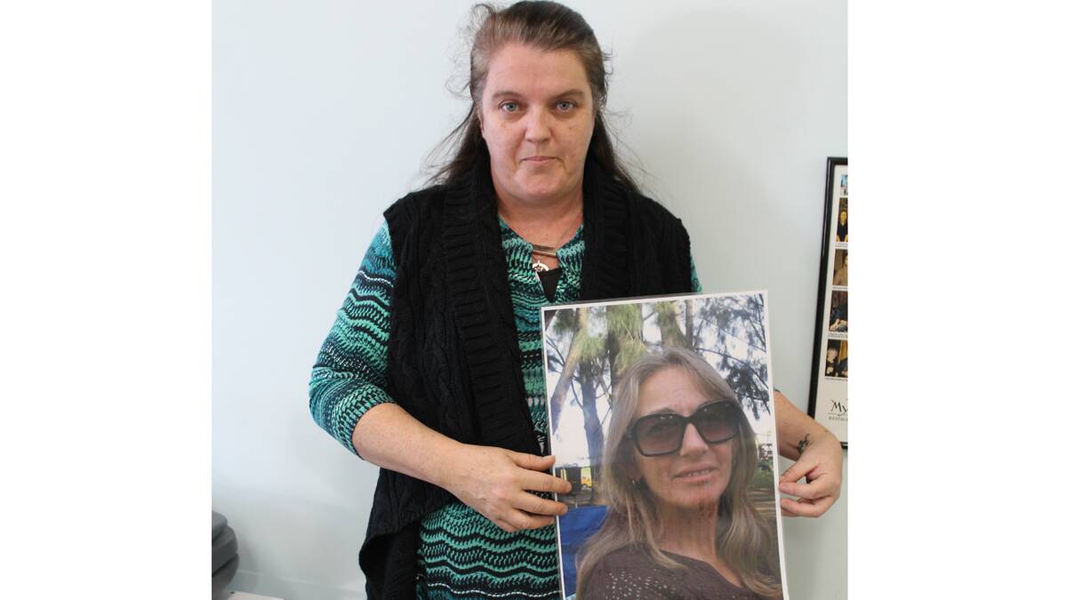 Rachael Bush, of Eden, holds 
a poster of her best friend, Sylvia Pajuczok, who has been missing, presumed dead, since 2008.
