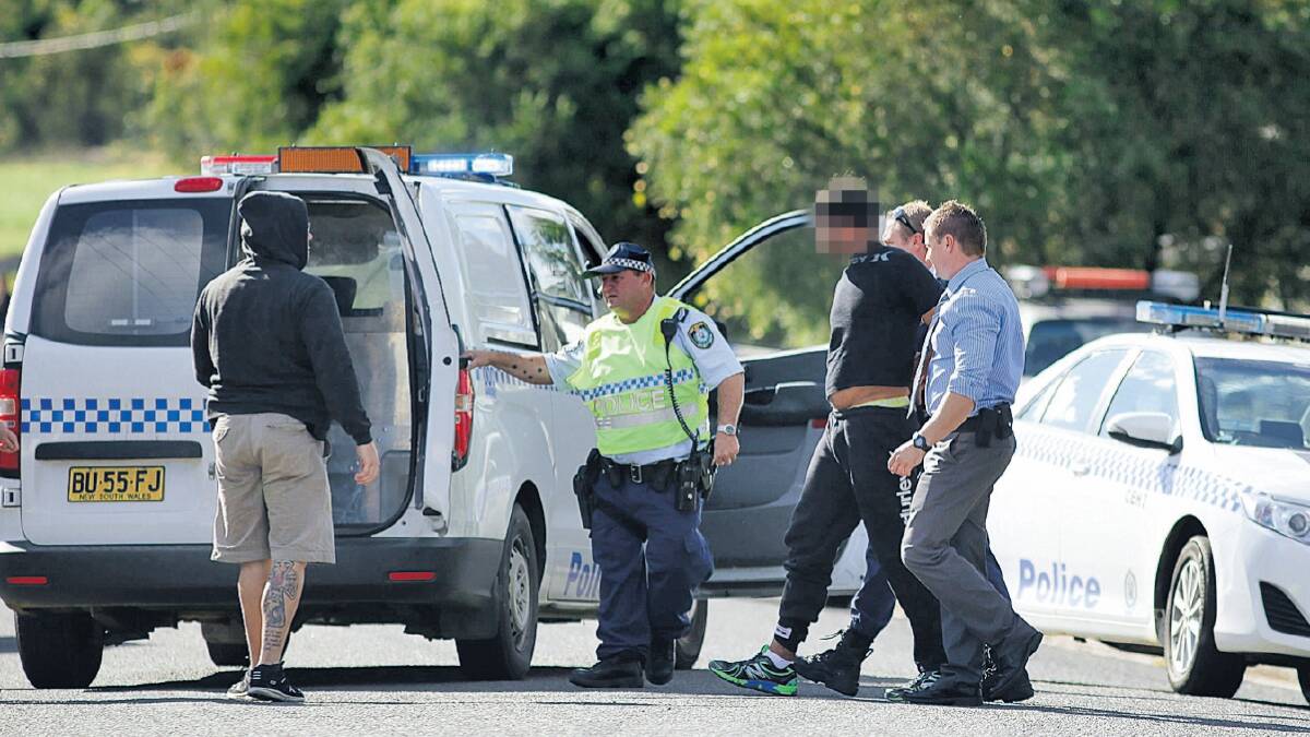 IN HIDING: Police officers apprehend three people they had been searching for in East Cessnock yesterday.  Pictures: Peter Stoop