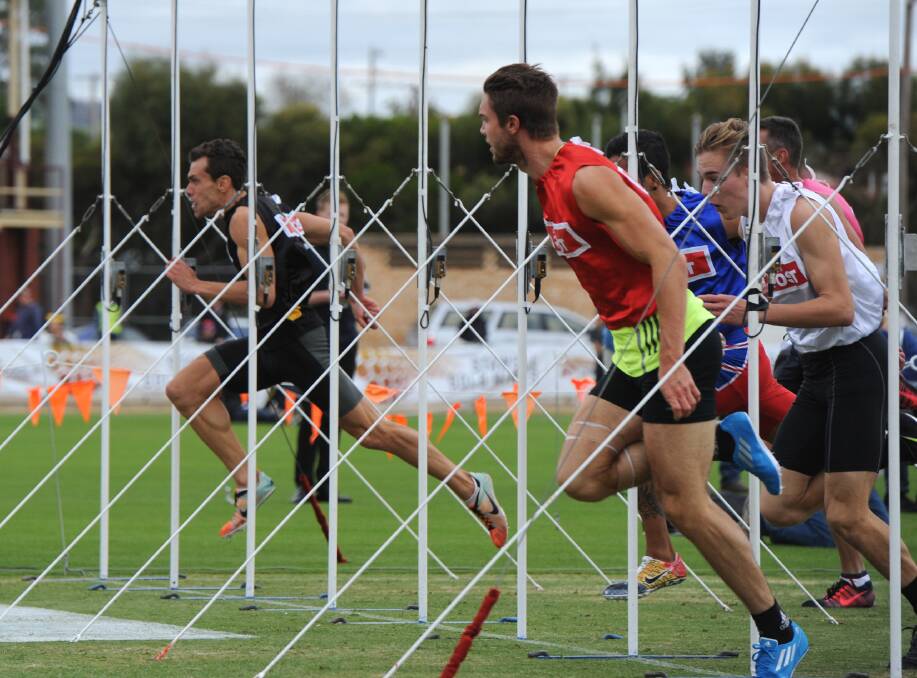 James Vine, red, holds off Shane Woodrow, black, in heat 7 of the 2014 Stawell Gift. 