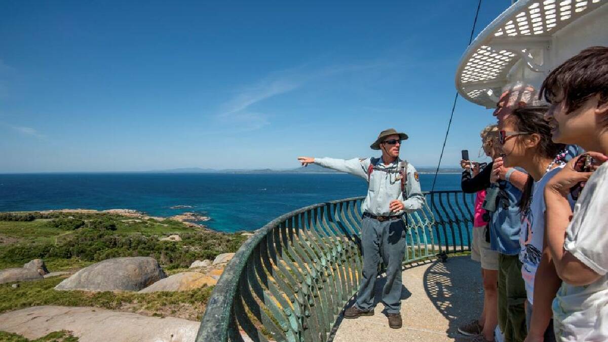 NAROOMA: Montague Island at Narooma has experienced record visitor numbers and field officer Brent Gresty is pictured leading a day tour on top of the lighthouse. Photo by Batemans Marine Park ranger Justin Gilligan 