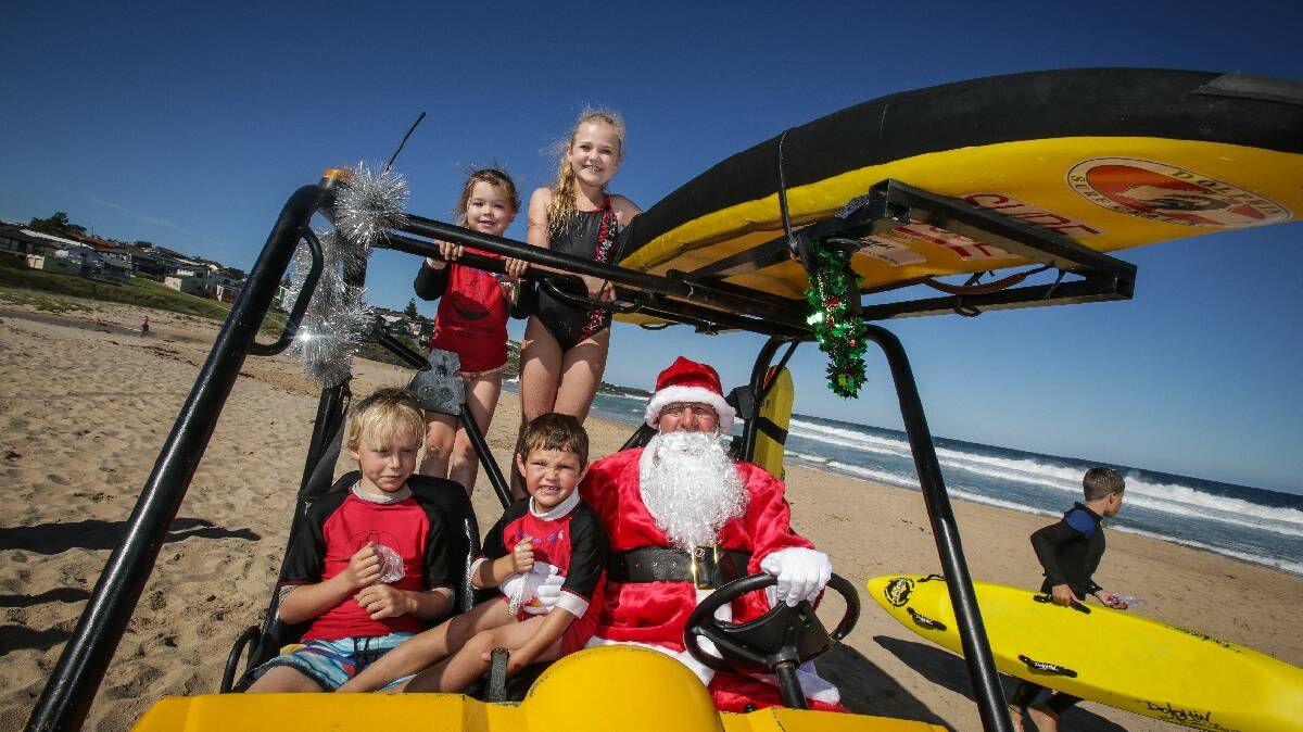 KIAMA: Kiama Downs Surf Club Nippers Christmas party. Santa with nippers Jade Wright, 5, Sienna Spence, 10, Kade Ovenden, 8, and Riley Gent at the end of their season. Picture DYLAN ROBINSON  