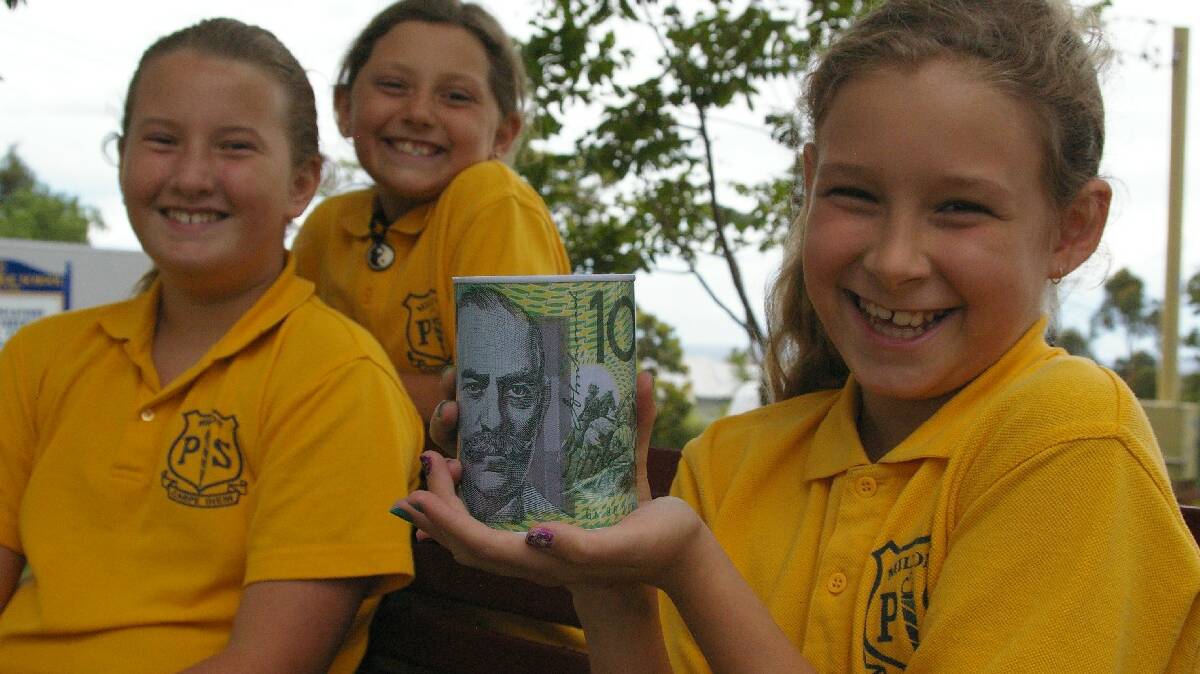 MILTON: Milton Public School student Teyani Elmaleh (front) pictured with her friend Molly Clarke and step-sister Nirvana Nesic-Short with the full money box she is giving to local boy Kiarn Roughley, who is battling leukaemia in a Sydney Hospital.  
