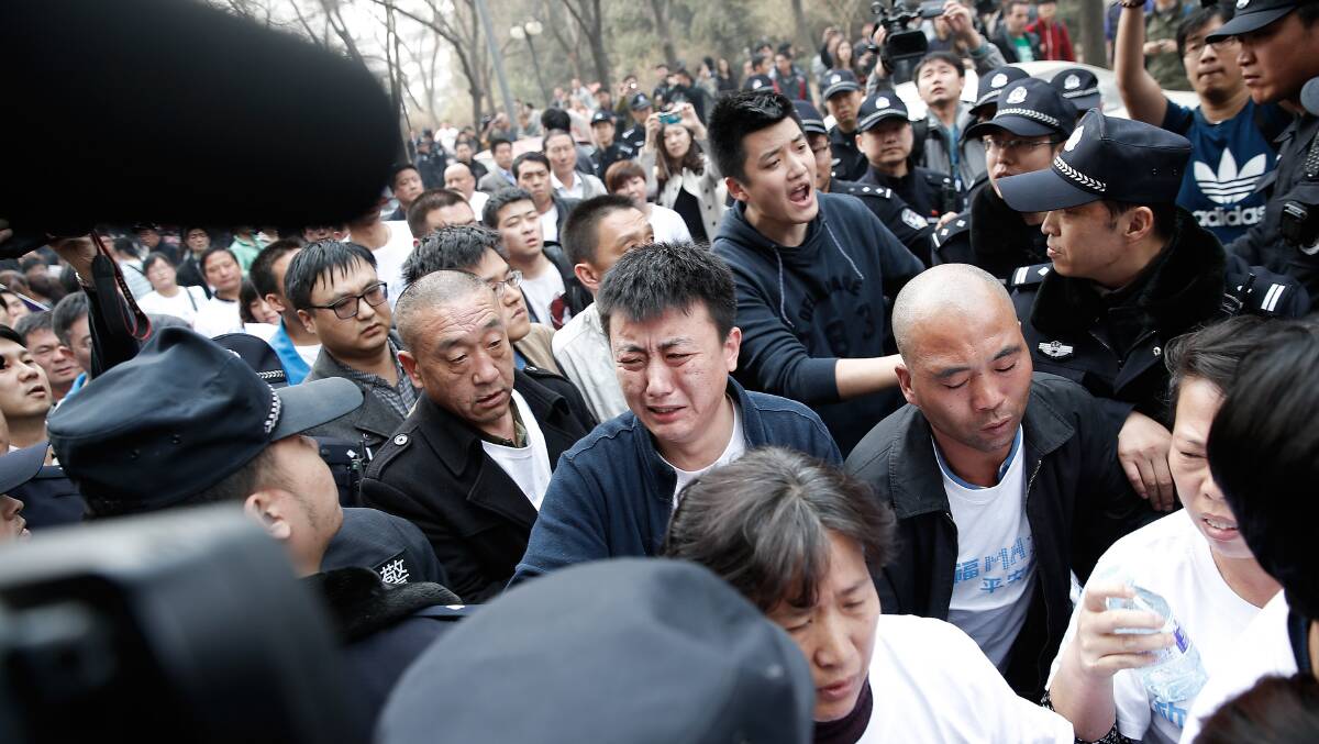 Chinese relatives of the passenger from the missing Malaysia Airlines flight MH370 clash with Chinese police outside the Malaysian Embassy in Beijing, China. Picture: Getty