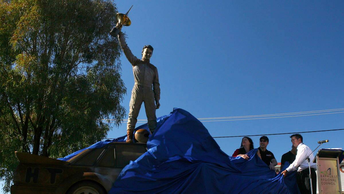 And here is Newcastle artist Julie Squires pulling the cover off her statue at Bathurst that  shows Peter Brock atop his VK after the historic win. Yes she knows he didn't do this in real life.