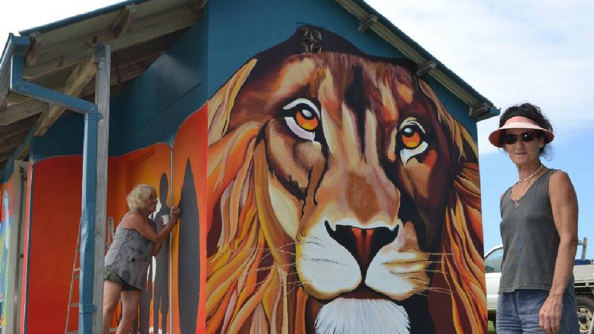 NAROOMA: Artist Jenni Bourke puts the finishing touches on Jess the lion at the Lions Park, Kianga toilet block assisted by Anne Spires.