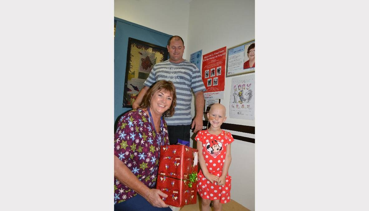 NOWRA: Children receiving treatment at Shoalhaven Hospital's children's ward like Georgia Fletcher were not forgotten at Christmas, with lots of gifts coming through the doors. Georgia is pictured with her dad, Brett, and nurse Sharon Robson of the local BRATs motorcycle club who donated vouchers and presents to support local families caring for sick children.