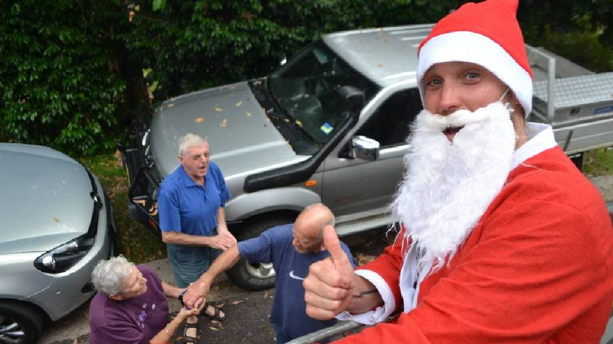  TILBA: River Cottage Australia host and the latest member of the Tilba RFS brigade Paul West played Santa on the back of the fire engine and here waits for donations.