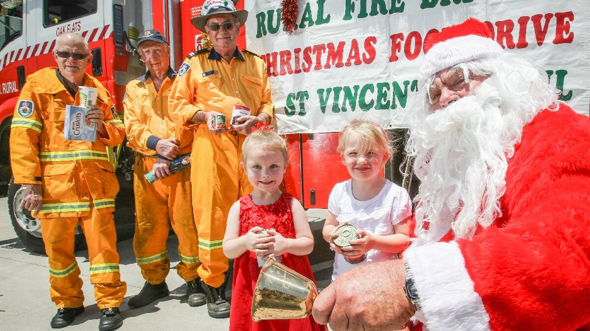 KIAMA: To help St Vincent De Paul again this year, Oak Flats Rural Fire Brigade will hold their annual Christmas food drive on December 7. Pictured are members Gary McDougall, Barry Brotherson and Chris Huer with Arianna Barlow, 3, and Holly Faulkner, 4, next to Santa (Ross Barlow). Picture: DYLAN ROBINSON  