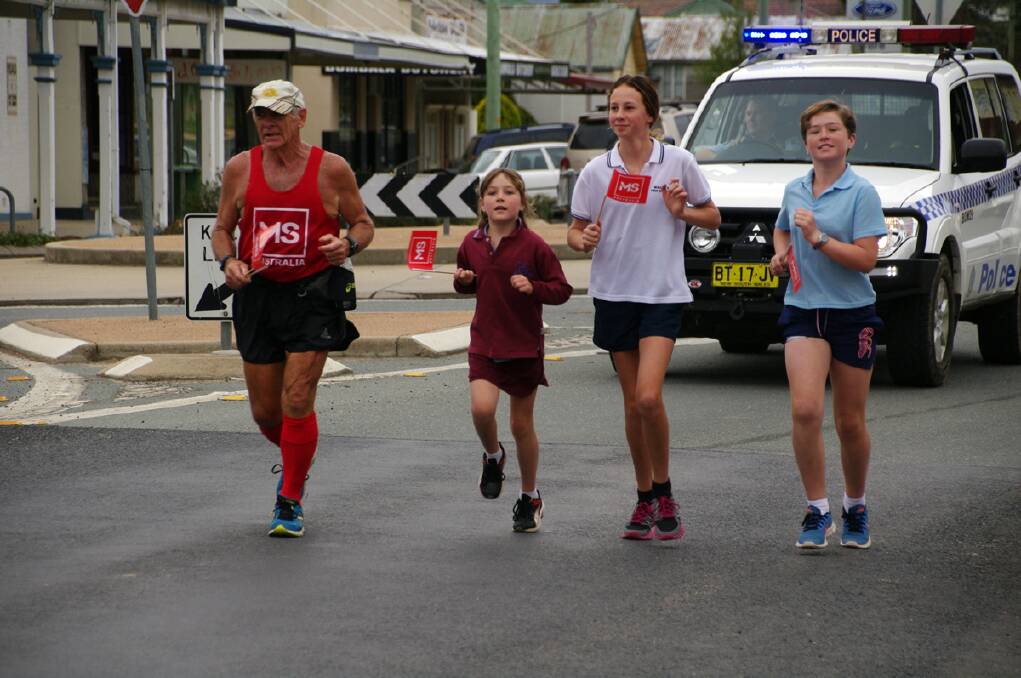 Running into the main street with Denis at the conclusion of his MS run from Eden to Bombala were young supporters, Bridie Hampshire, Molly Badewitz and Karter Hampshire. 
