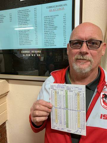 Bombala golfer Wayne Elton proudly holds aloft his score card after breaking the course record on Saturday.