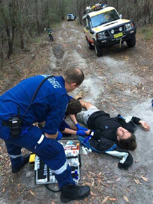 Paramedics attending to Darcy McKay after his crash on a rutted out dirt track in Pambula Beach. 