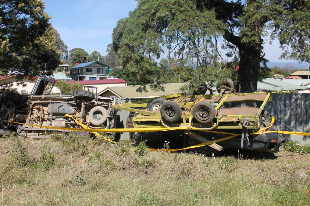METAL MESS: A ute towing another car on a trailer lost control on the Princes Highway and rolled off the road near Wolumla on Thursday morning. Photo: Alana Beitz