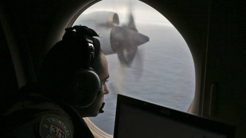 In this March 22, 2014 file photo, flight officer Rayan Gharazeddine scans the water in the southern Indian Ocean off Australia. 